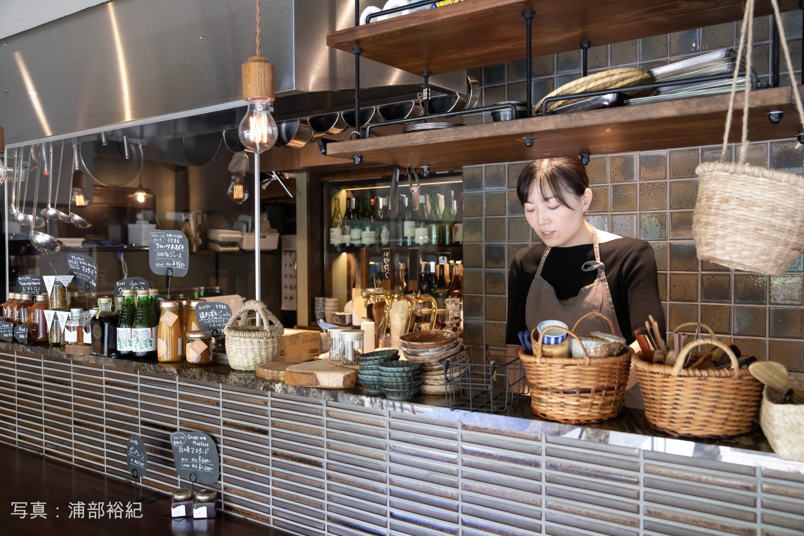 開店前、仕込みを行う店主の古越亜弥氏。客席からはキッチン越しにガラス張りのセラー内部が見える。